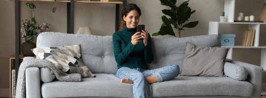 A person sitting on a couch looking at a phone