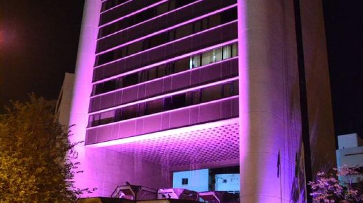 Φωτογραφία κτιρίου εταιρείας φωτισμένη συμβολικά μωβ