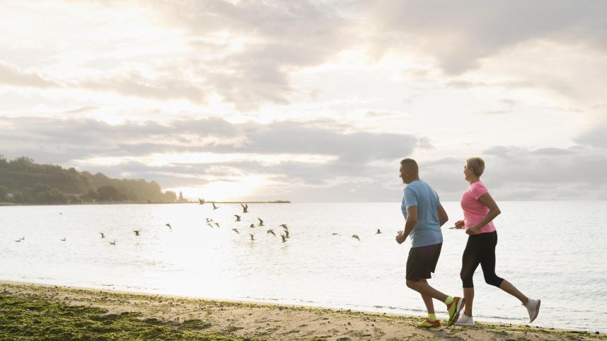 side-view-elder-couple-jogging-beach